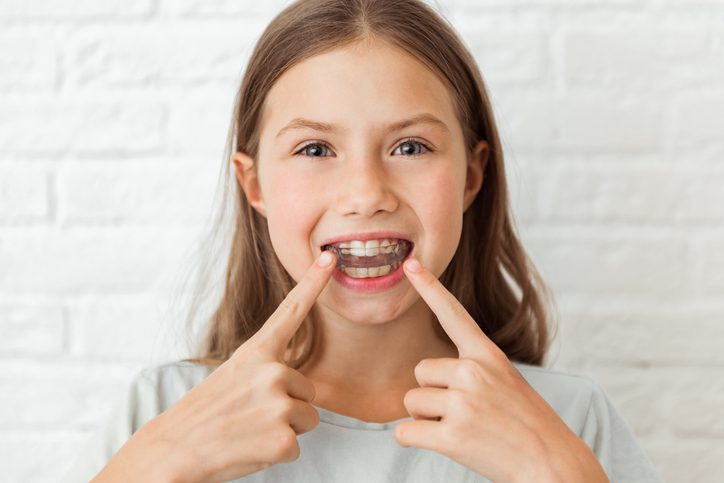 little girl shows clear retainer in a Perth orthodontic clinic